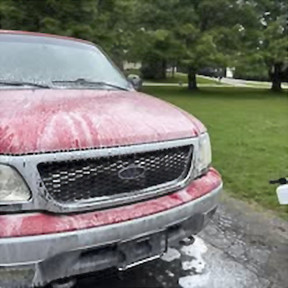 Red pickup covered with wash foam